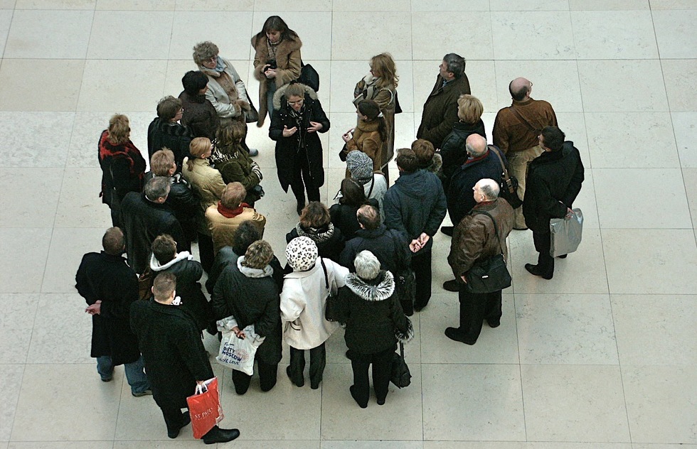 A group listens to a guide give a lecture.