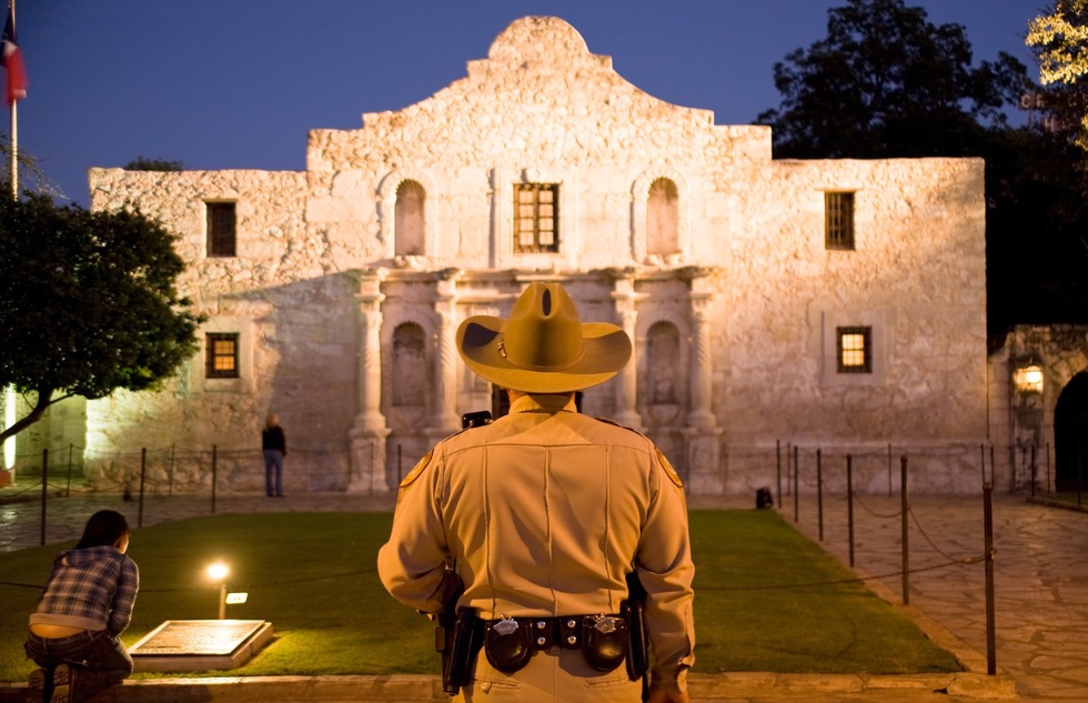 A sheriff stands in front of the Alamo in San Antonio