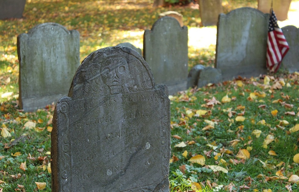 Puritan-designed gravestone with a winged death's head etched into it.