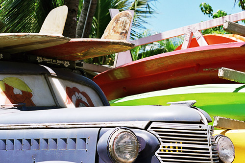 Surfboards on classic automobiles.