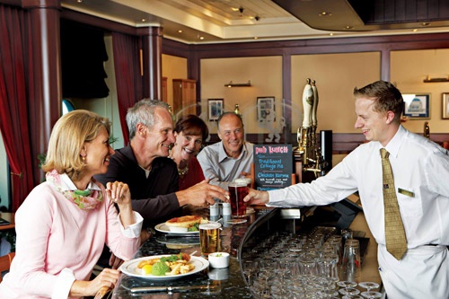 Model passengers down a pint with lunch at QM2's Golden Lion Pub. Photo: Courtesy of Cunard Line