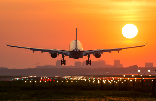 Airplane landing at sunrise