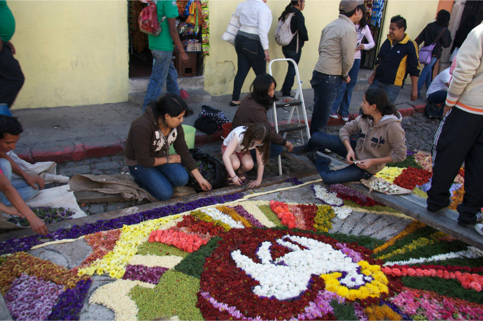 The author’s daughter helps make an alfombra, or rug of flowers, in honor of Easter celebrations in Antigua, Guatemala