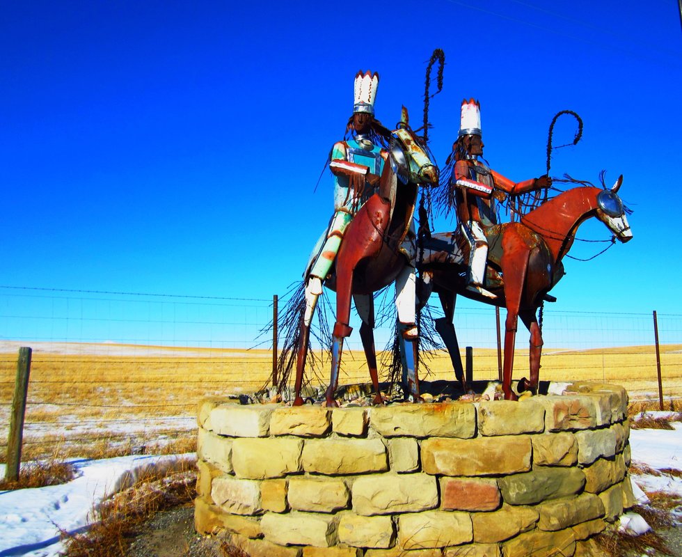 Statue of two Native American warriors astride their horses at the entrance to the Blackfeet Reservation, Montana.