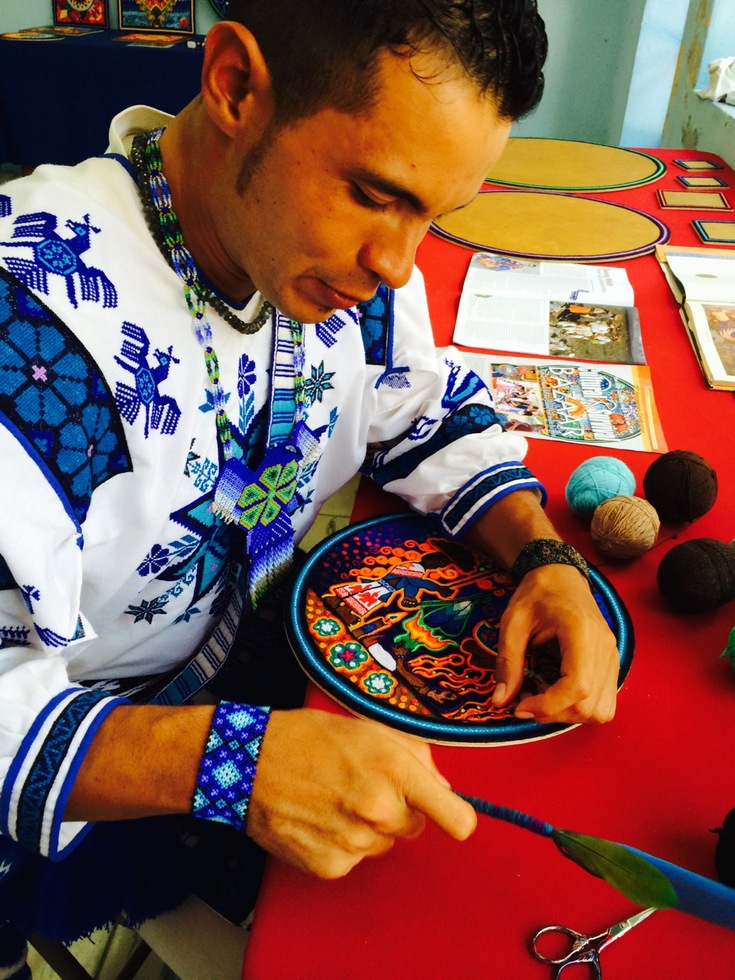 Cilau Valadez, a Huichol artist, creates a yarn painting