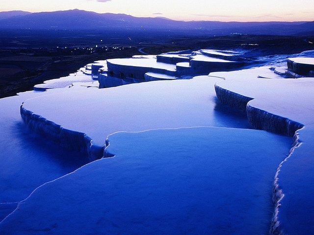 Blue and purple terraced hot springs of Pamukkale seen at dusk
