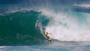 Surfer in Hawaii rides a huge wave.