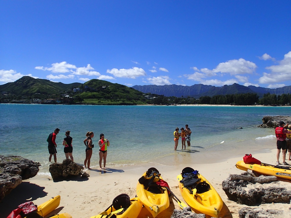 People on a beach with kayaks 
