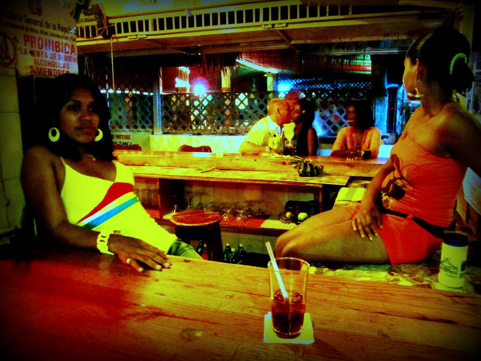 Two women hang out at a Dominican bar