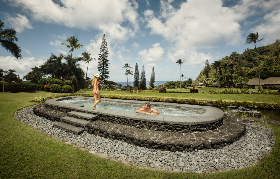 A couple bathes in the lava rock Jacuzzi at the Travaasa Hana resort