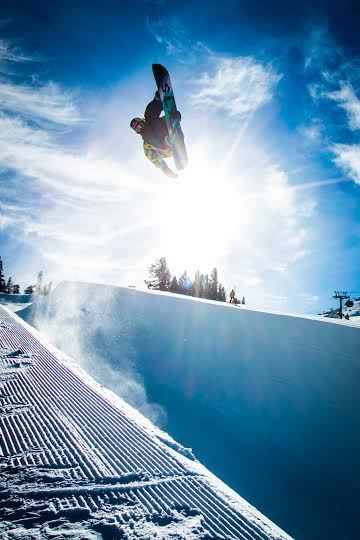 A snowboarder "flying" through striking blue sky at Mammoth resort, California.
