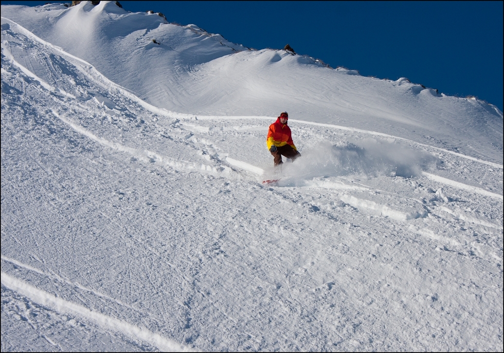 Snowboarding down a powdery slope at Livigno Resort, Italy.