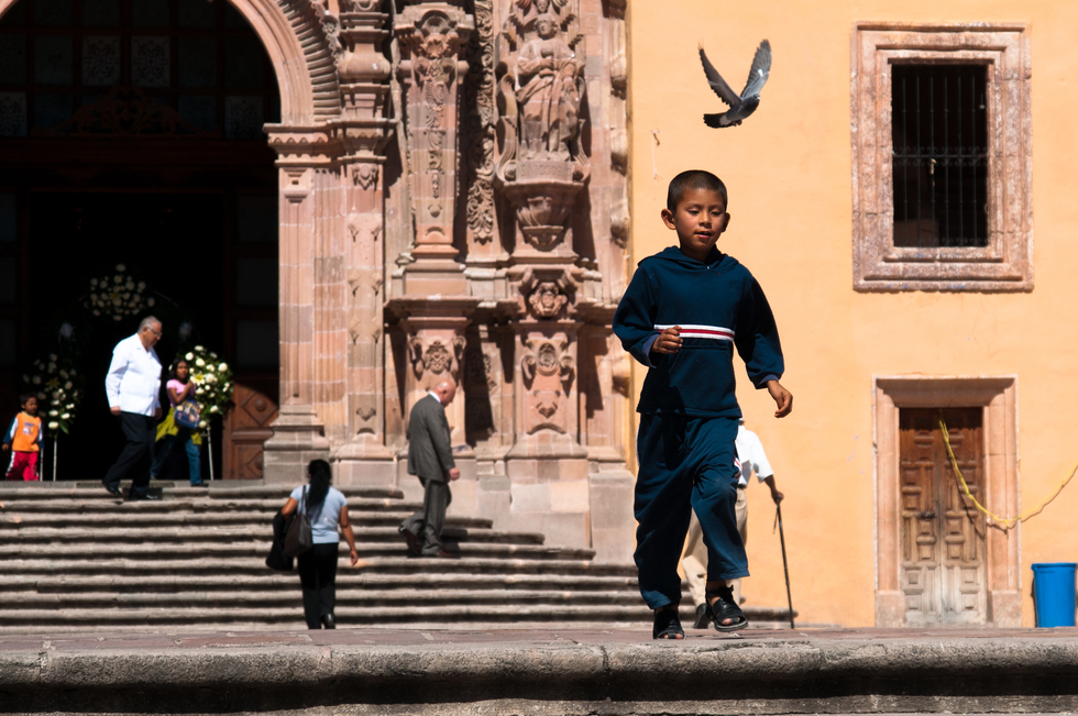 A boy walks through a plaza in Guanajuato