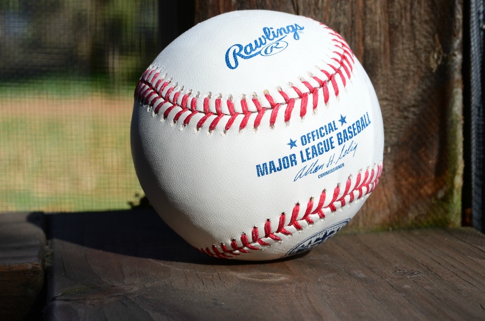 A closeup of a baseball with the Major League Baseball emblem. 