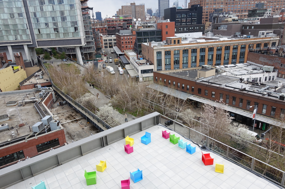 A terrace at the Whitney Museum, filled with multi-colored chairs and overlooking the Highline Park