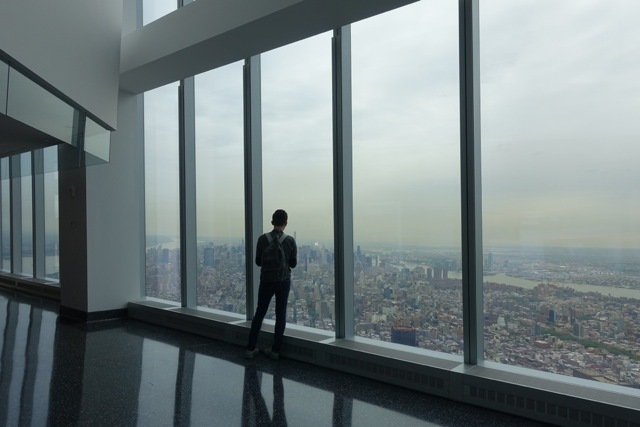 A man looks out the window of the One World Observation Deck