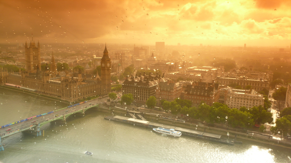 Aerial view of an orange overcast London through a rain speckled glass pane
