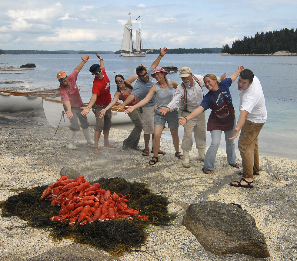 A crew prepares a lobster bake on a beach in Maine.