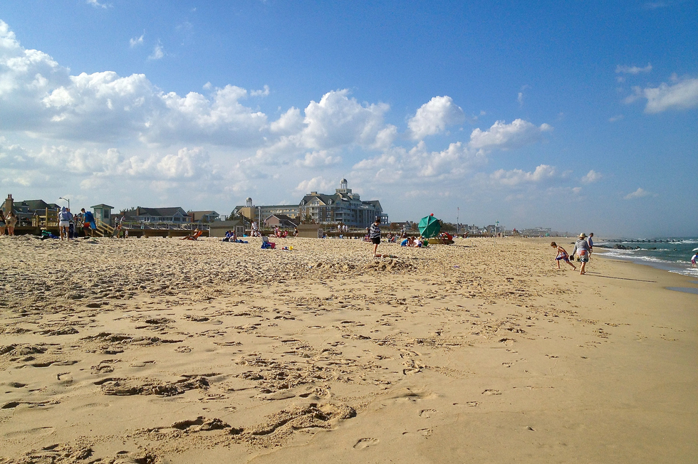 Beach front with people and buildings on the horizon line