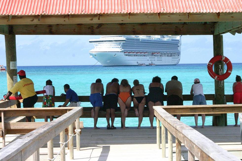 Passengers gaze out over the azure waters at their cruise ship.