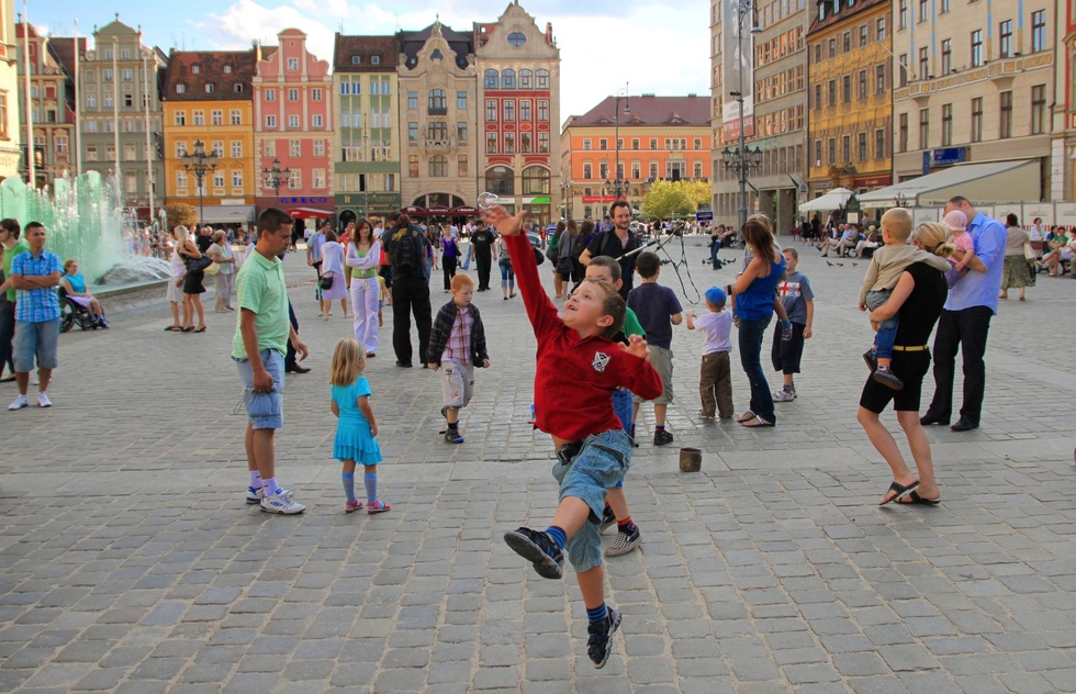 A boy tries to catch a soap bubble in the rynek (market square) of Wroclaw, Poland