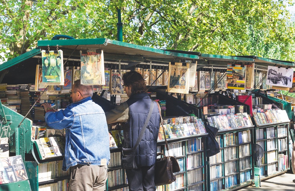 Shoppers browse the wares at a stall selling second-hand books and memorabilia along the Seine in Paris