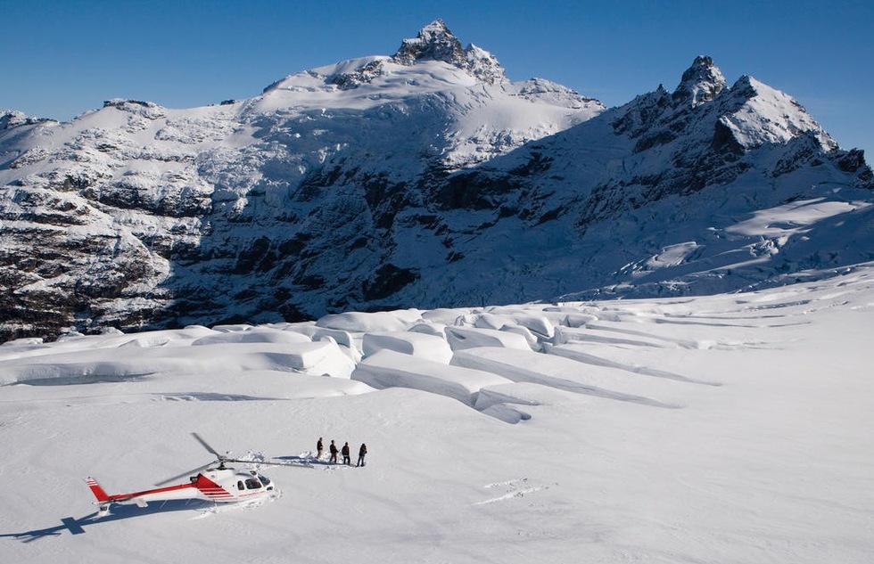 Skiers set off from a helicopter in the Southern Alps of Queenstown, New Zealand