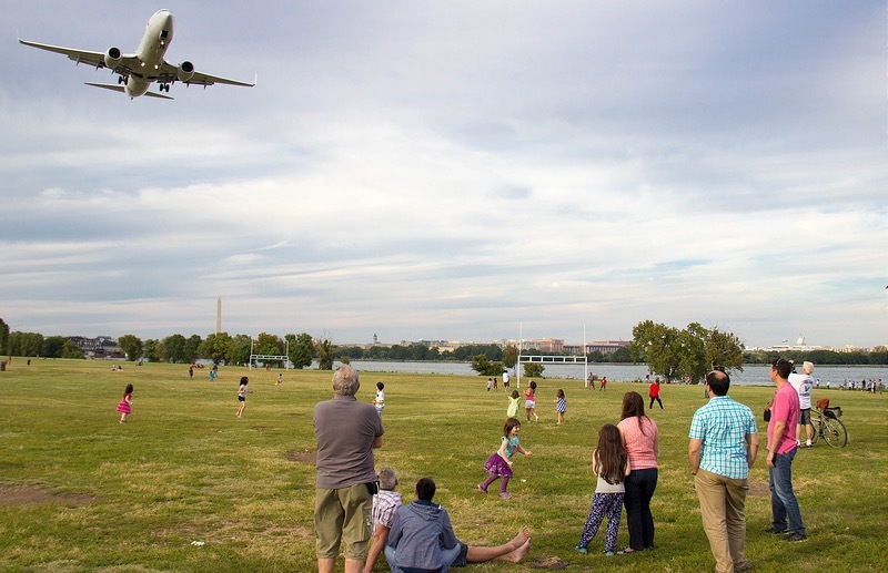 Plane flies over kids playing in park