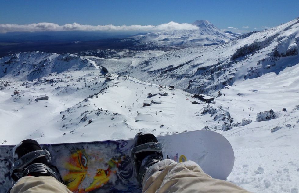 Snowboarder looks down into the valley