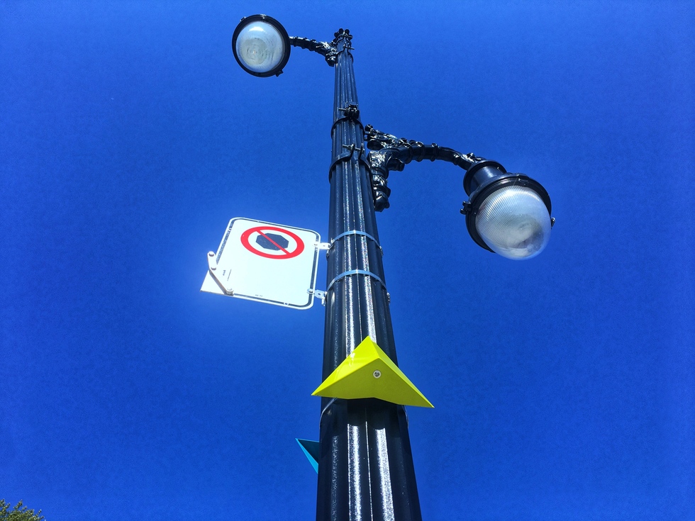 A yellow marker on a street lamp in Montreal