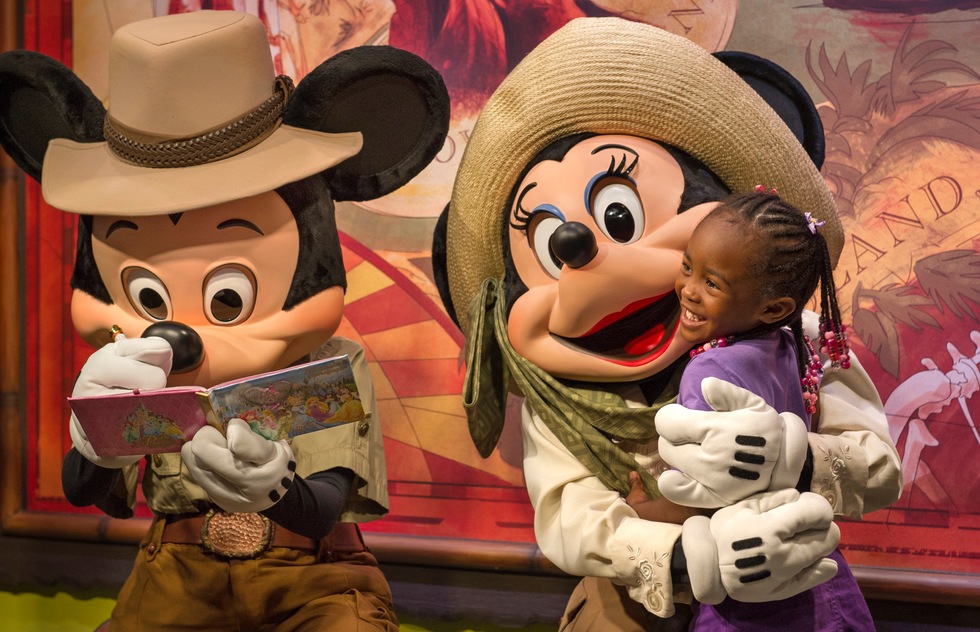 Mickey and Minnie Mouse greet a child at Walt Disney World in Florida.