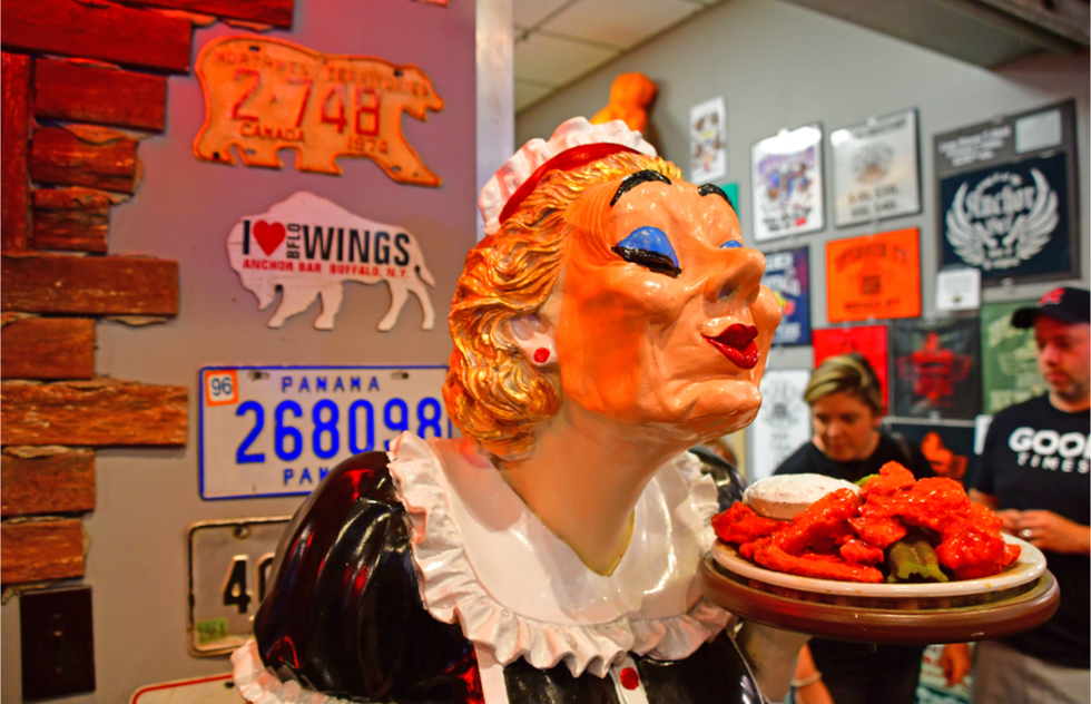 A statue holding a plate of chicken wings at the Anchor Bar in Buffalo, NY