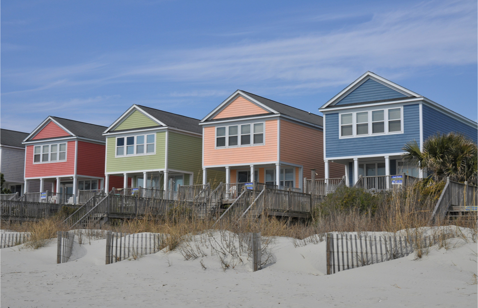 Four brightly colored vacation homes on a beach