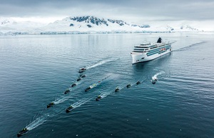 The Viking Octantis, led by Zodiac boats, plows through Arctic waters. 