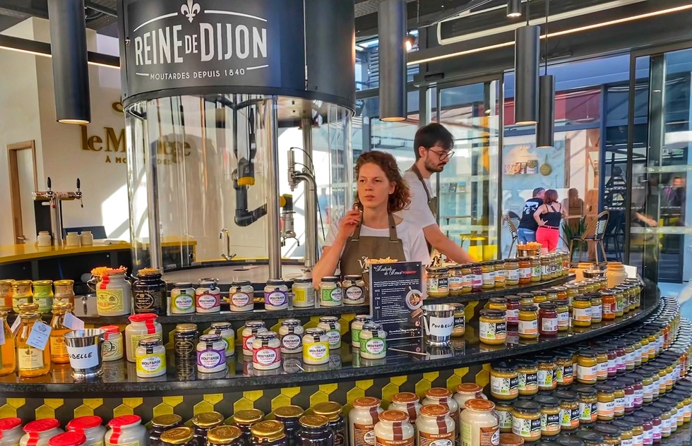 Best things to see and do in Dijon, France: Two workers prepare samples at a mustard store in the gastronomic village of the Cité Internationale de la Gastronomie et du Vin