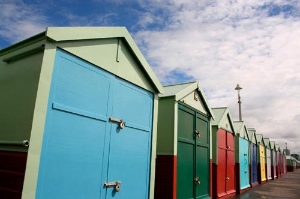 Brightly coloured beach huts in a row on Brighton seafront, England