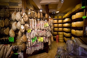 Enjoy the local specialities--here, Parma's hams and cheeses.