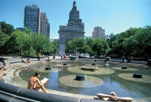 People sitting around a water feature in Washington Square Park, Greenwich Village.