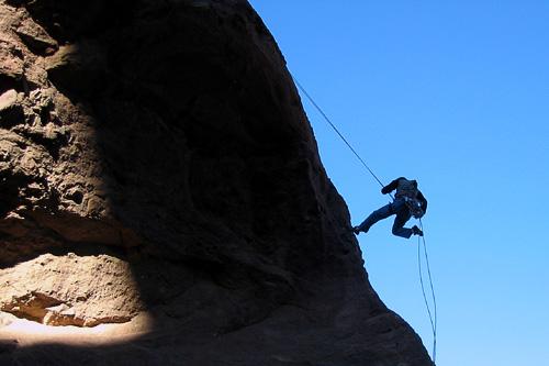 A rock climber rappels down Camelback Mountain.