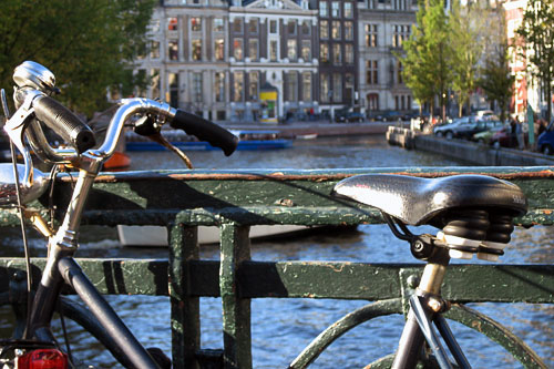 a bike sits on a bridge overlooking the Amsterdam canals
