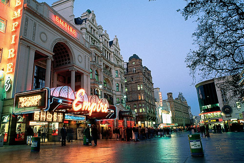 A view of nightfall on Leicester Square lit by the bright neon lights of the Empire Cinema.