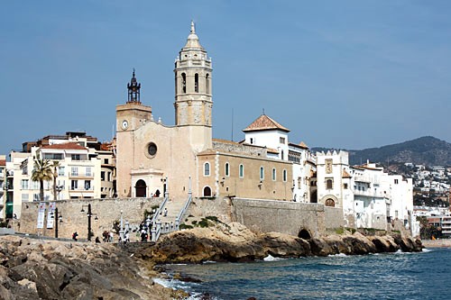 The Església de Sant Bartomeu i Santa Tecla clings to the promontory along Sitges.