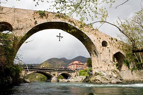 The mountain villages of the Asturias and Cantabria. The Puente Romano, adorned with a cross, arches over the Río Sella in Cangas de Onís.
