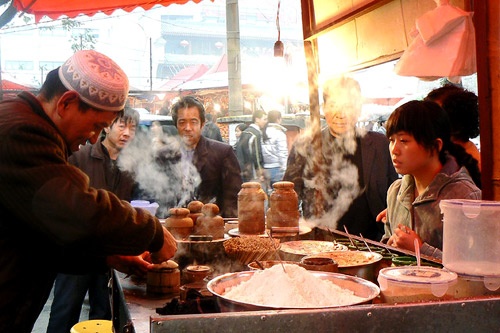 Sweet pastry being removed from its mold, under watchful eyes, in the Muslim Market in Xian, China.
