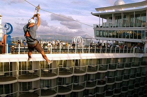 A zipline lets passengers fly nine stories above Allure of the Seas' Boardwalk neighborhood, starboard to port.