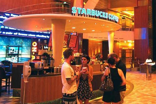 Allure of the Seas passengers caffeinate at the world's first shipboard Starbucks.