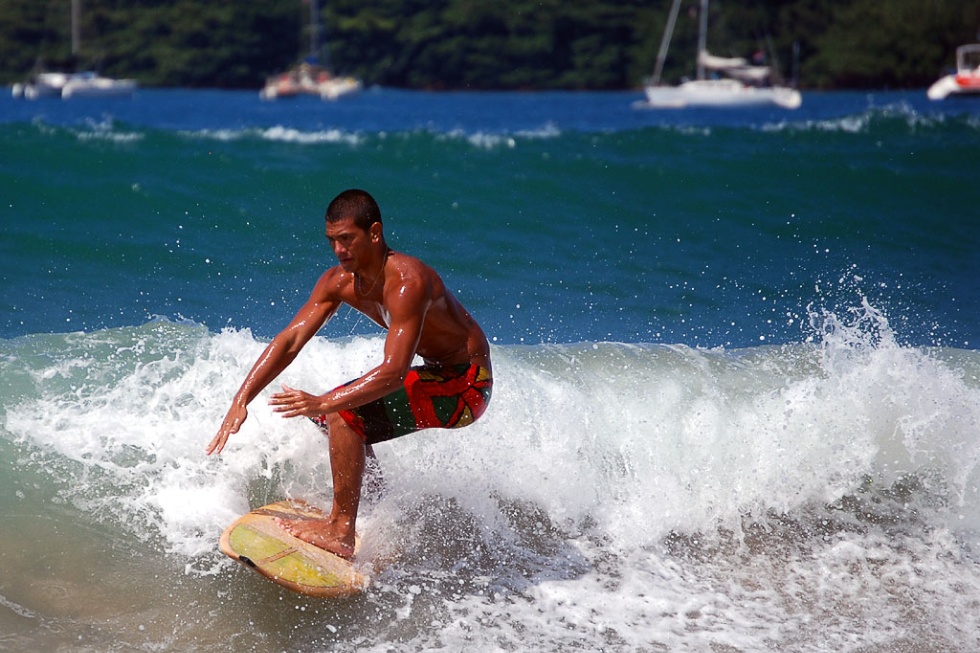 Surfer at Kauai's Hanalei Bay beach.