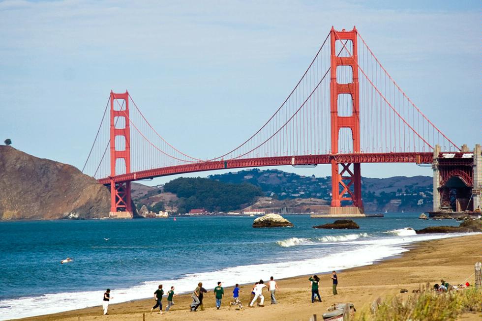 Kids playing soccer on the beach near the Golden Gate Bridge in San Francisco, California.