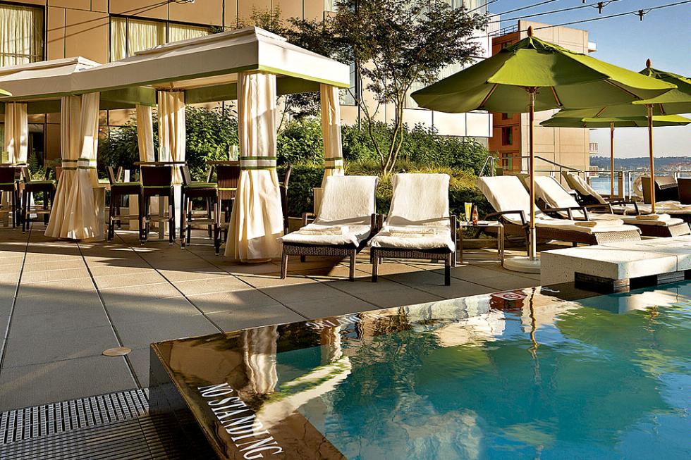 Poolside cabanas and lounge chairs dot the rooftop pool at the Four Seasons Hotel Seattle.