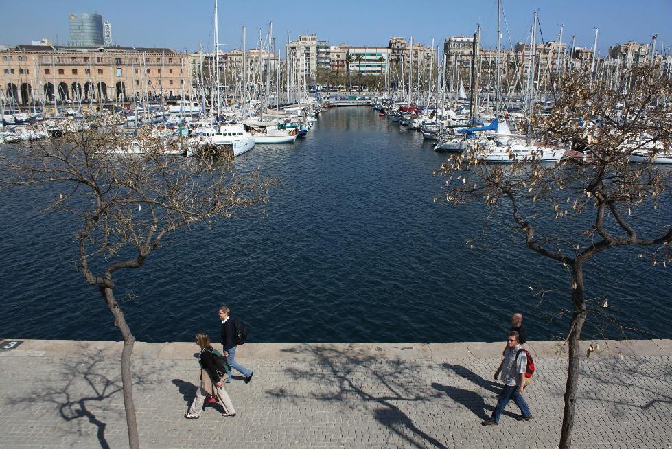 Walkers strong along the waterfront in Port Vell, Barcelona, Spain